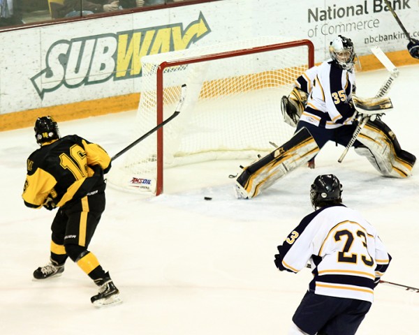 Duluth Marshall's Luke Pavelich sneaks a puck past Hermantown goalie Adam Smith during the 7A boys hockey final at Amsoil Arena in Duluth.