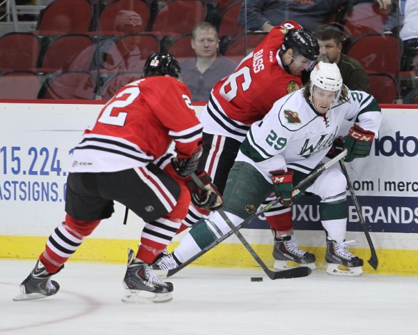 Marc Hagel (right, in white) battles for the puck against Rockford on Nov. 6 at Wells Fargo Arena. (Iowa Wild Photo/Reese Strickland)