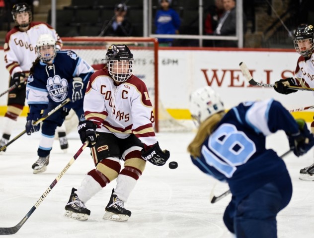 Blaine's Sam Auman fires a shot toward the Lakeville North net as the Cougars' Kelsey Olsen defends. (MHM Photo / Tim Kolehmainen)